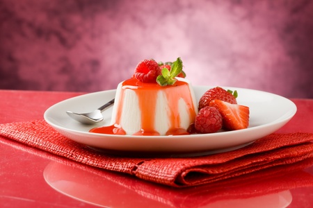 photo of italian panna cotta dessert with strawberry sirup and mint leafの写真素材