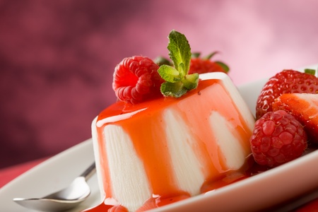 photo of italian panna cotta dessert with strawberry sirup and mint leafの写真素材