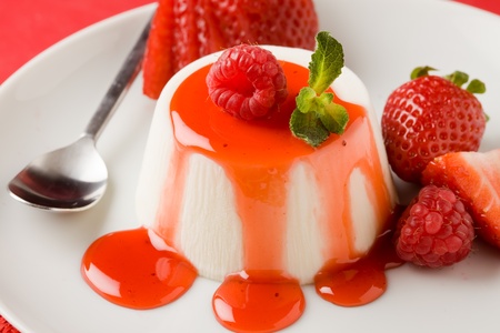photo of italian panna cotta dessert with strawberry sirup and mint leafの写真素材