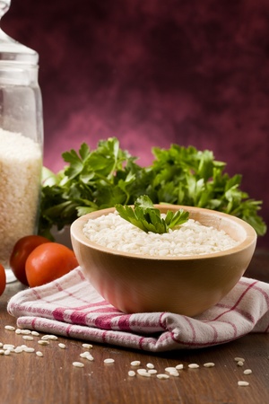 photo of ingredients for risotto with parsley on wooden tableの写真素材