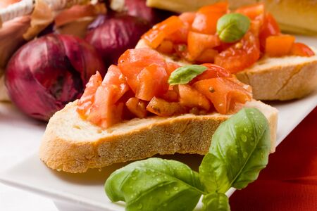 photo of delicious italian bruschetta with basil and ingredientsの写真素材