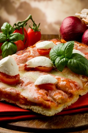 delicious slice of pizza with buffalo mozzarella and cherry tomatoes on wooden tableの写真素材