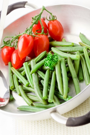 photo of french beans inside a pan with cherry tomatoesの写真素材