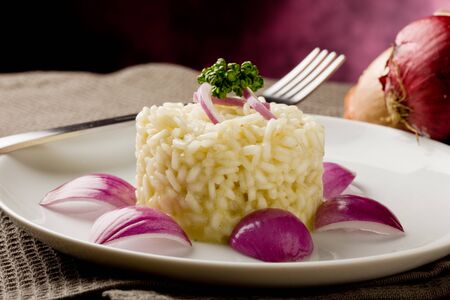 photo of delicious risotto with red onions on wooden tableの写真素材