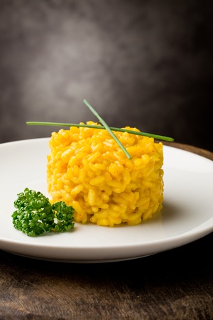 photo of delicious yellow risotto with saffron on wooden tableの写真素材