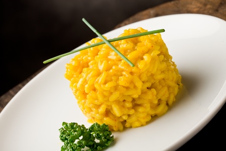 photo of delicious yellow risotto with saffron on wooden tableの写真素材