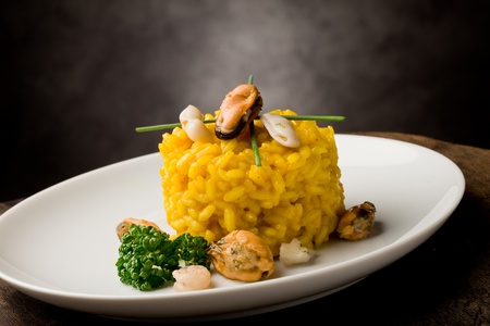 photo of delicious risotto with saffron and seafood on wooden tableの写真素材