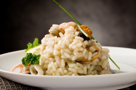 photo of delicious risotto with seafood and parsley on it の写真素材