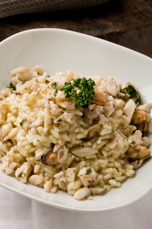 photo of delicious risotto with seafood and parsley on it の写真素材