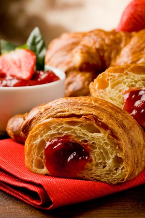 delicious golden croissants filled with strawberry marmeladeの写真素材