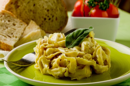 delicious italian fresh tortellini with butter and sage on green wooden table の写真素材