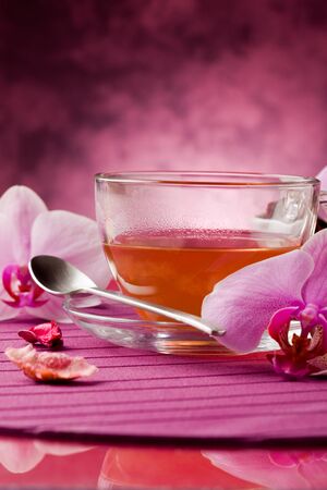 photo of orchid tea inside a glass cup with big orchid flowerの写真素材