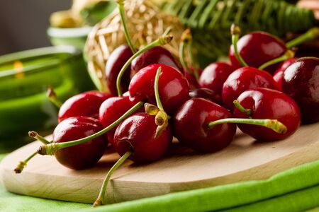 photo of delicious cherries on cutting board with decoration arroundの写真素材
