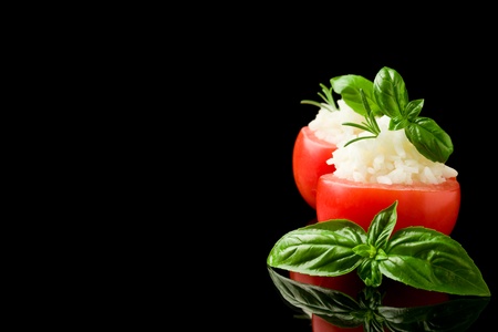 delicious stuffed tomatoes with rice on black isolated backgroundの写真素材