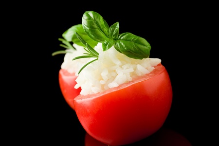 delicious stuffed tomatoes with rice on black isolated backgroundの写真素材