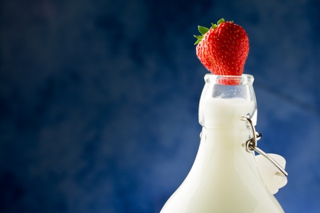 milk bottle with fresh red strawberry on it の写真素材
