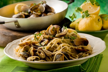 photo of delicious pasta with clams in front of a green backgroundの写真素材