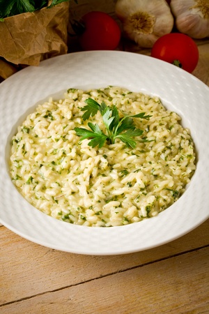 photo of delicious risotto dish with herbs on wooden tableの写真素材