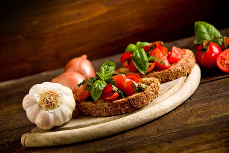 photo of delicious bruschetta appetizer with fresh cutted tomatoes and basilの写真素材
