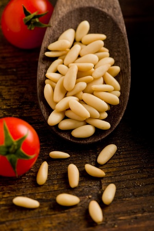 photo of fresh pine nuts close-up on wooden spoon の写真素材