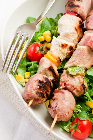delicious broiled meat skewers on white tableの写真素材