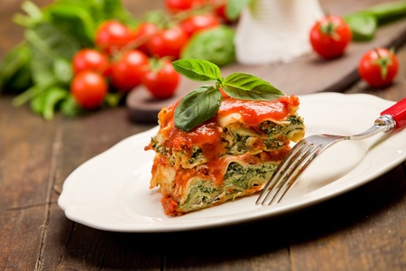 delicious homemade lasagne with ricotta cheese and spinach on wooden tableの写真素材