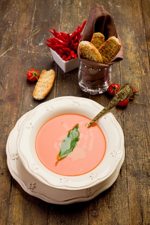 fresh homemade tomato soup with bay leaf on wooden tableの写真素材