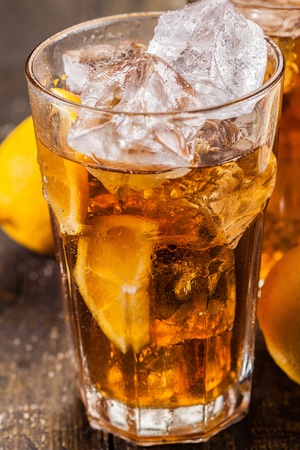 lemon ice tea on brown wooden table with lemons aroundの写真素材