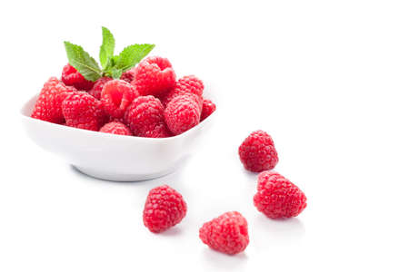 photo of fresh raspberries inside a bowl with mint on white backgroundの写真素材