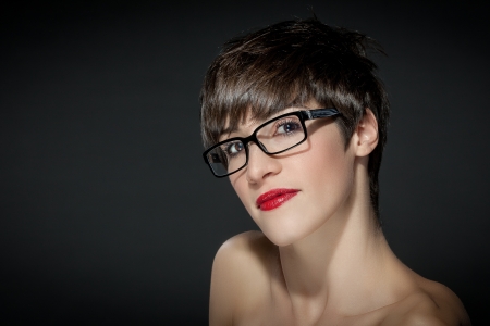 Beautiful woman with glasses in front of a grey backgroundの写真素材