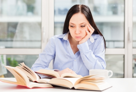 Photo Female Student learning at home with different booksの写真素材