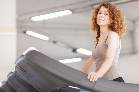 photo of young woman doing workout on a treadmill