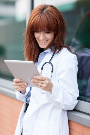 female doctor looking at the tablet pc while smilingの写真素材