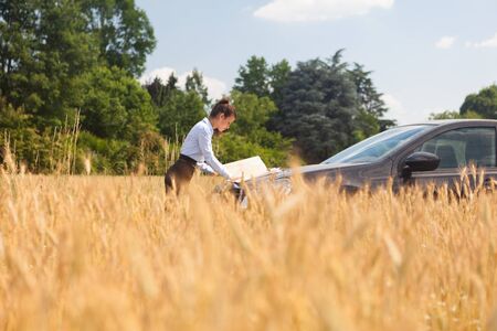 Businesswoman lost in a field and looking at a map