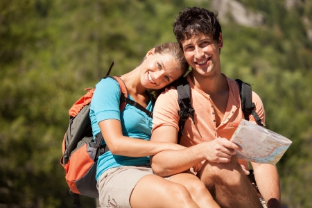Photo of beautiful couple in love with trekking outfit looking towards the camera while smilingの写真素材