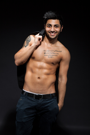 Sexy man with great abs over black isolated background wearing sunglassesの写真素材