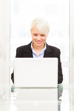Photo of young female manager with notebook in her officeの写真素材
