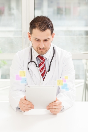 Photo of male doctor with tablet in his studioの写真素材