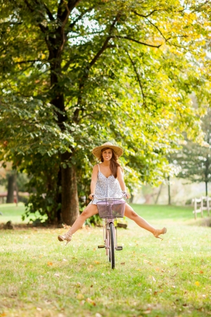 Photo of a beautiful girl cycling in a park の写真素材