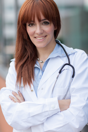 photo of smiling caucasian female doctor standing next to windowの写真素材