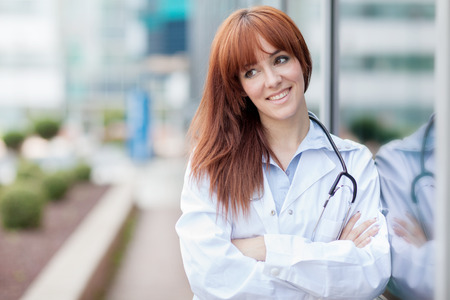photo of smiling caucasian female doctor standing next to windowの写真素材