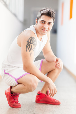 Caucasian smiling man in sportswear in corridorの写真素材