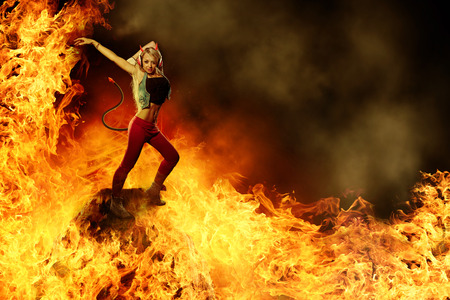 Blonde female devil is dancing in the fireの写真素材