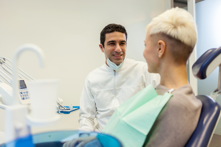 photo of european male dentist speaking with his blonde female patientの写真素材