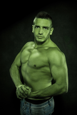 Portrait of green bodybuilder over black backgroundの写真素材