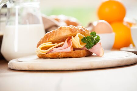 Delicious ham and cheese croissant on a wooden tableの写真素材
