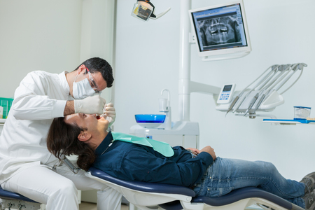 photo of european male dentist doing a checkup on a 40 years old manの写真素材