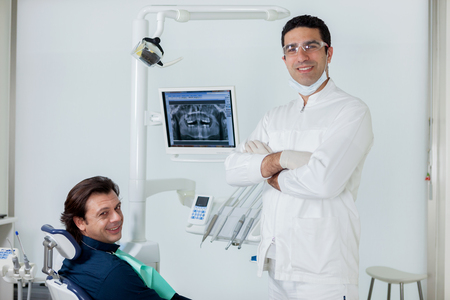 Smiling dentist with his patient in the dental studioの写真素材