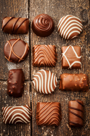 Photo of chocolate pralines over old wooden tableの写真素材