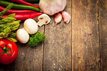 Photo of colorful vegetables over old wooden tableの写真素材